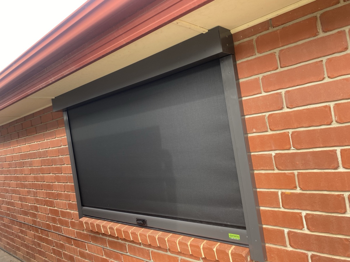 Black mesh blind on brick window